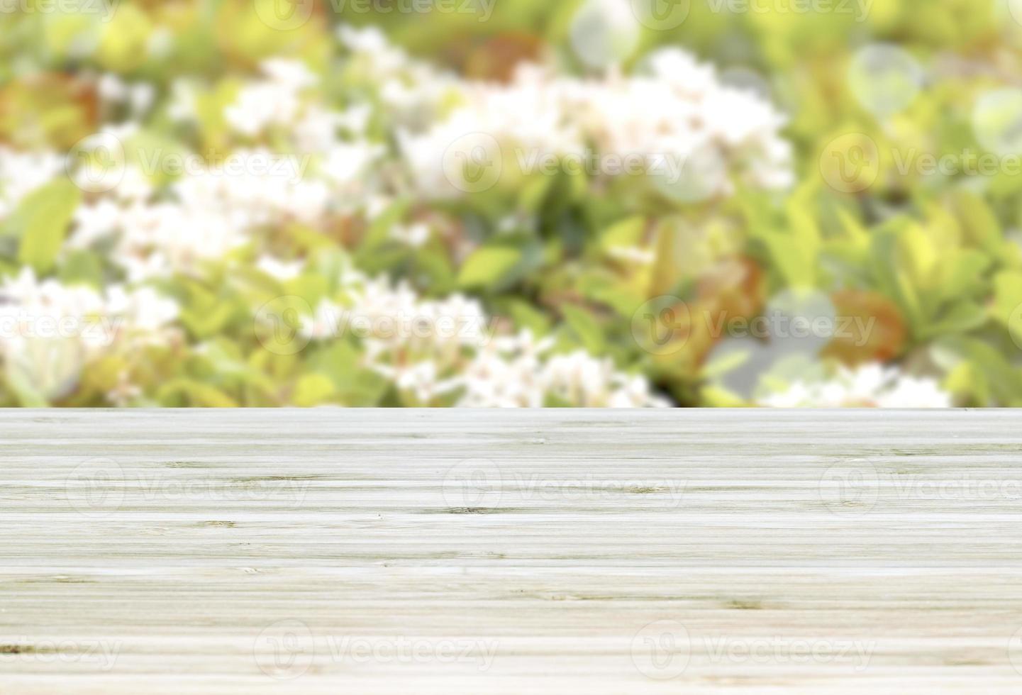 Template empty top table view with white flower and green leaf blur effect background photo