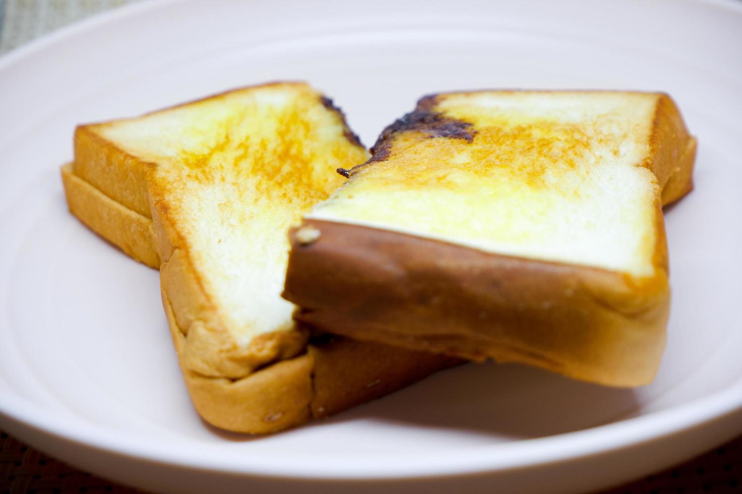 Selective focus of brown toast on pink plate with flower decoration. photo