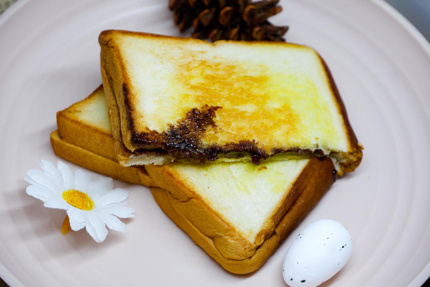 Selective focus of brown toast on pink plate with flower decoration. photo