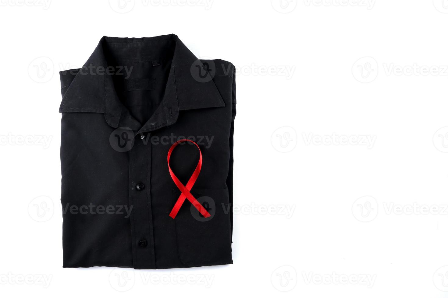 Red ribbon on a black shirt on a white background. Modern treatment and healthcare. AIDS awareness concept. photo