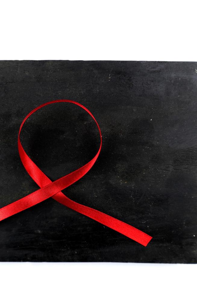 red aids ribbon on old wood background photo