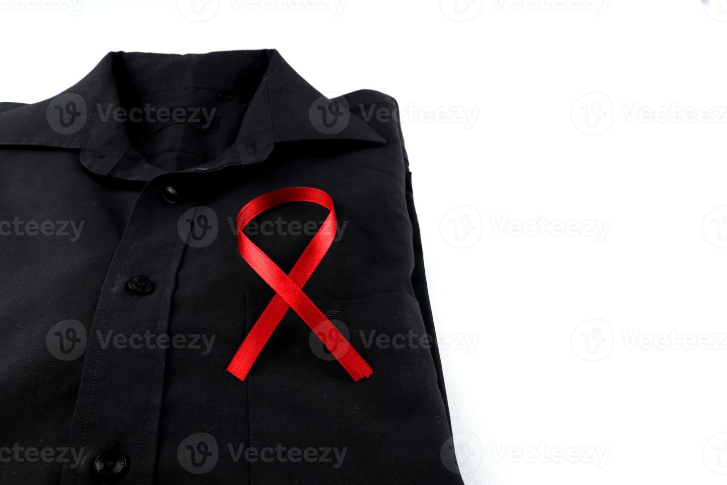 Red ribbon on a black shirt on a white background. Modern treatment and healthcare. AIDS awareness concept. photo