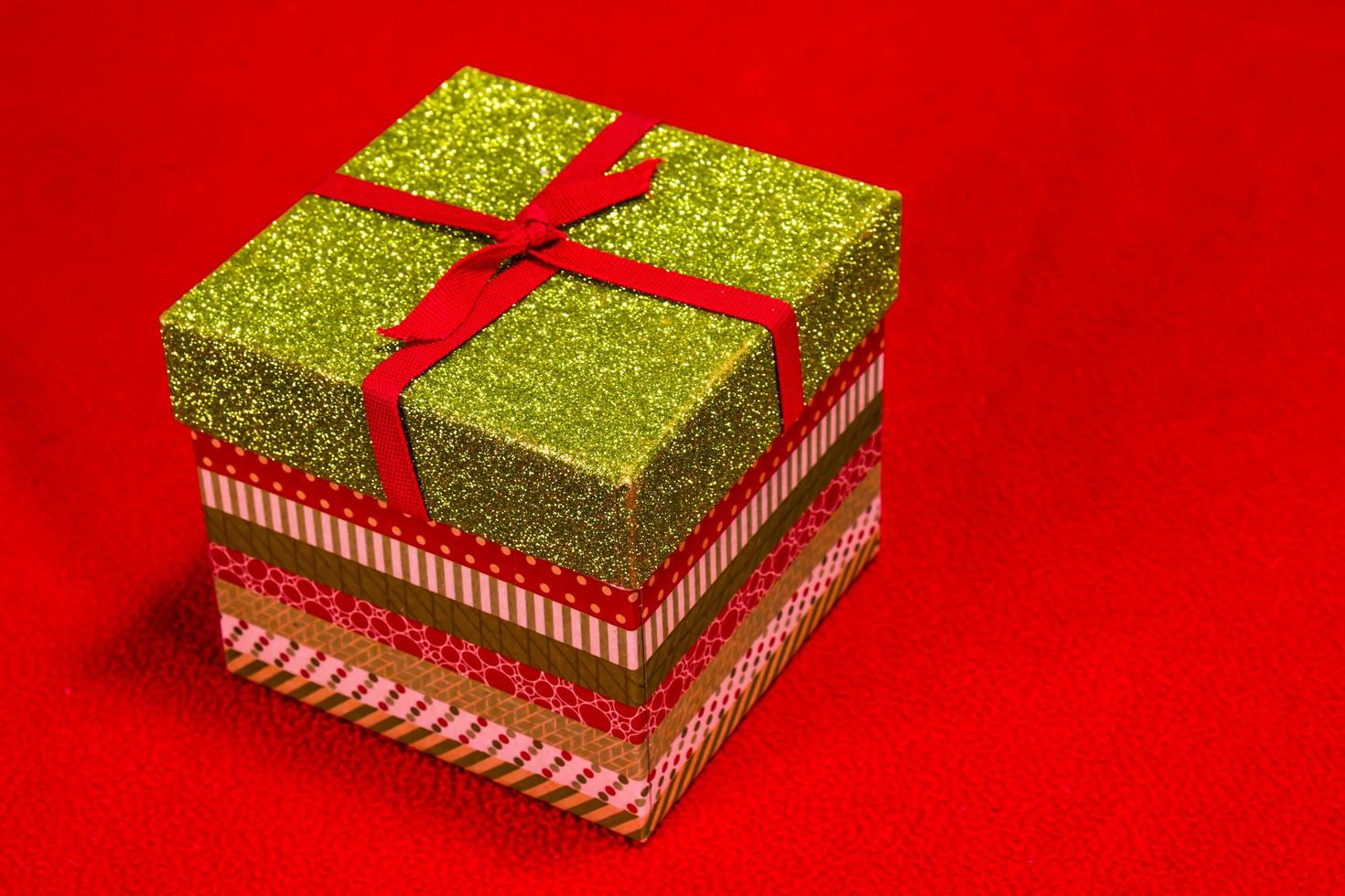 caja de navidad colorida con tapa sobre fondo rojo foto