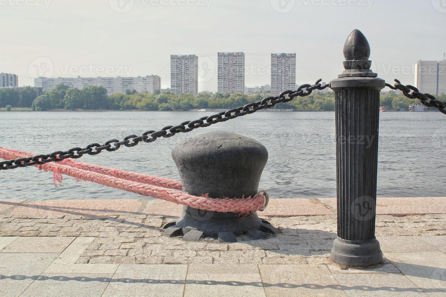 bolardo de estacionamiento de metal de acero para barcos con cuerda de amarre náutica rosa asegurada en un muelle en el puerto. puerto de vela muelle muelle. transporte de navegación marítima de agua marina. lugar para arreglar botes y yates foto