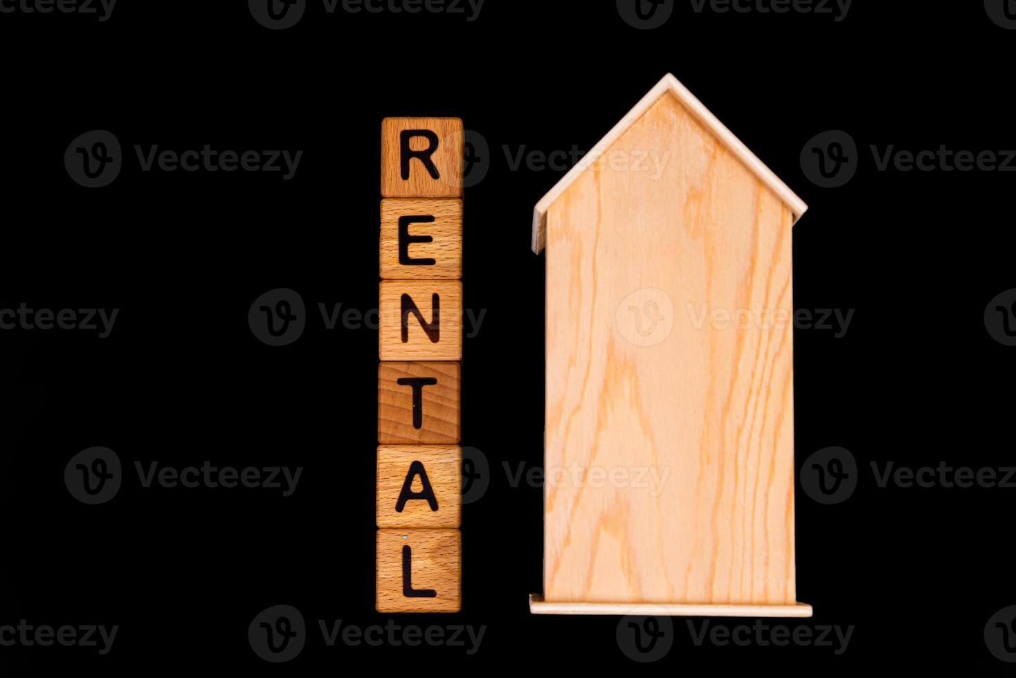 wooden house mockup with house keys, wooden cubes with words rent sale , buy and loan. on black background photo