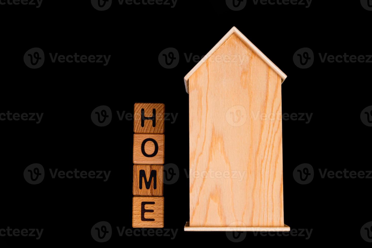 wooden house mockup with house keys, wooden cubes with words rent sale , buy and loan. on black background photo