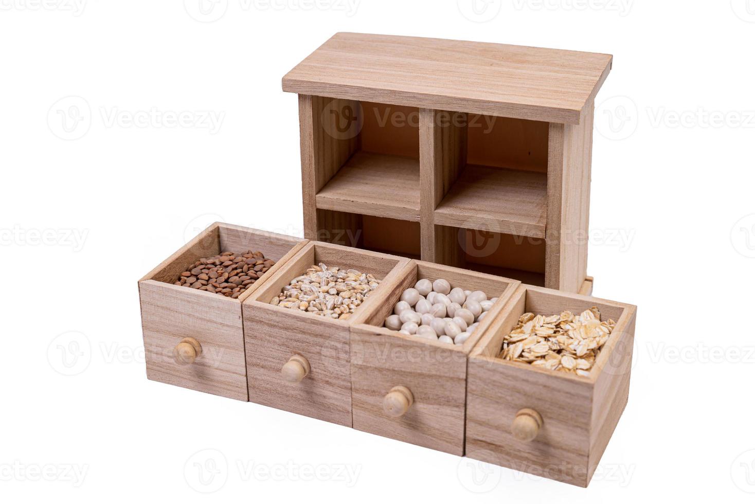 patrón de cereales crudos, frijoles y semillas, textura de vista superior, mezcla de grañones en caja cuadrada de madera. pequeña caja de madera con celdas con frijoles lentejas semillas de avena aisladas en fondo blanco, foto