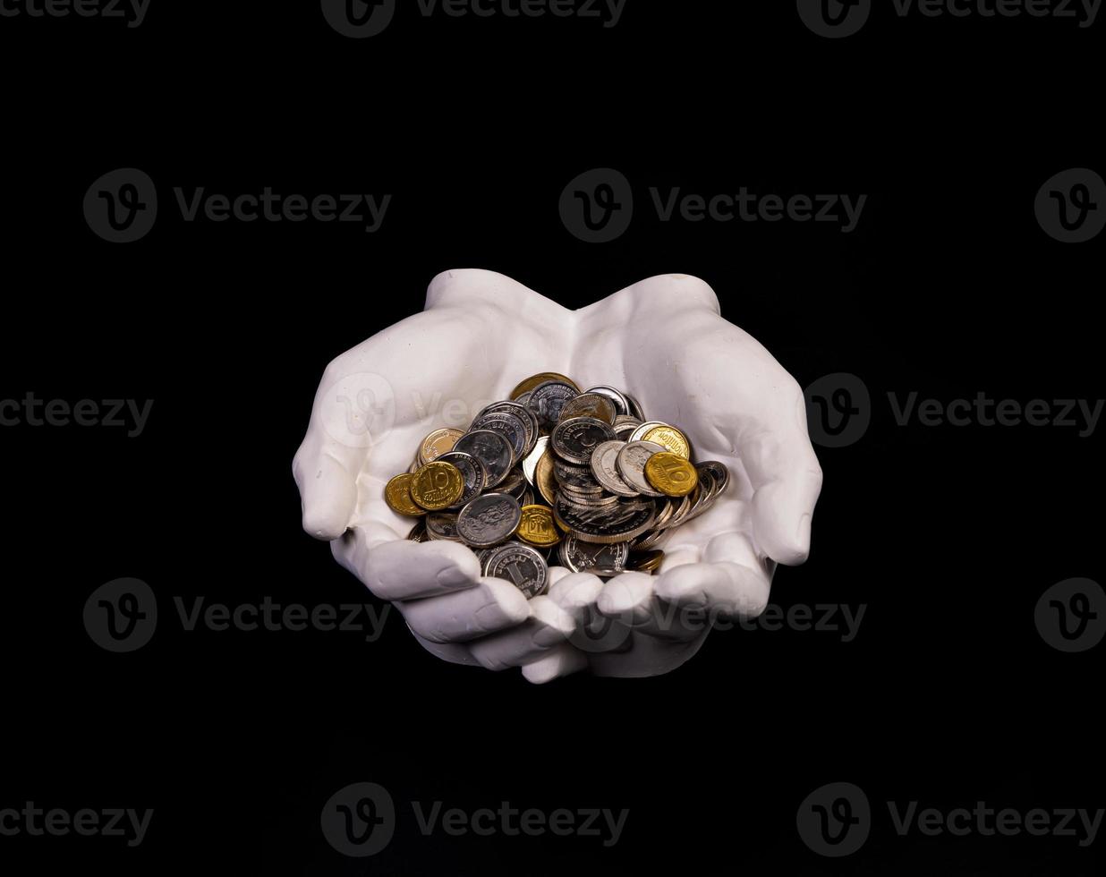 hands holding coins selective and soft focus isolated on black background with copy space. photo