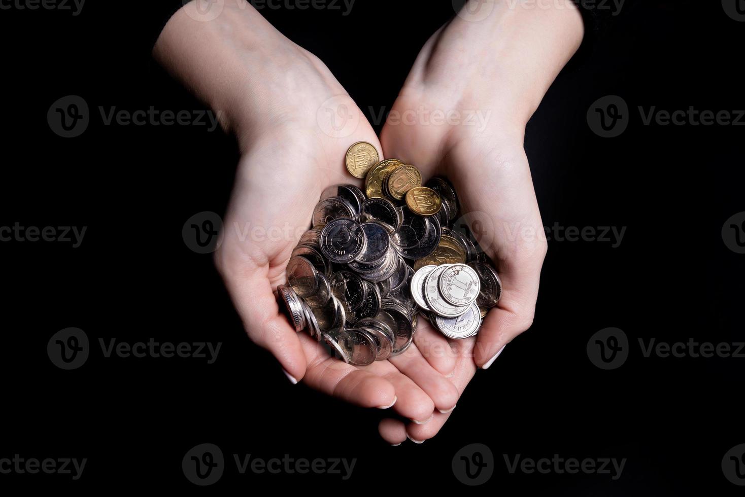 hands holding coins selective and soft focus isolated on black background with copy space. photo