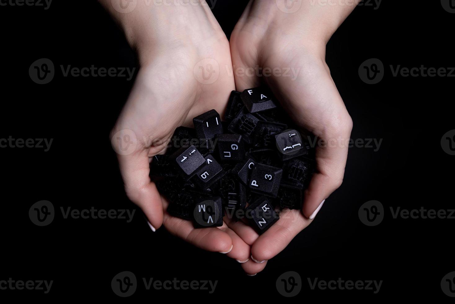 female hands holding keyboard buttons isolated on black background photo