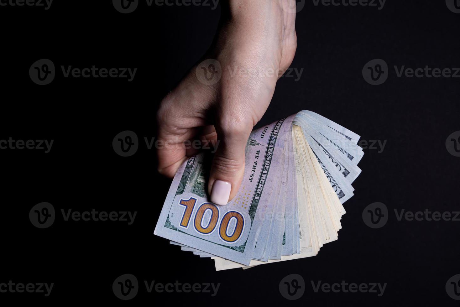 two hands with dollars. Closeup female hand giving money for something with isolated on black background,count, paying, shopping with dollar, corruption, counting dollar banknotes on black photo