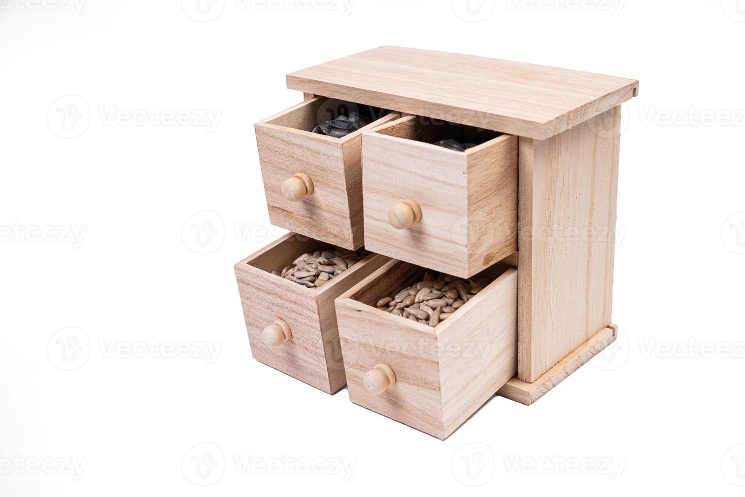 Wooden box cells filled with various spices. wooden box with sunflower seeds, peeled and raw photo
