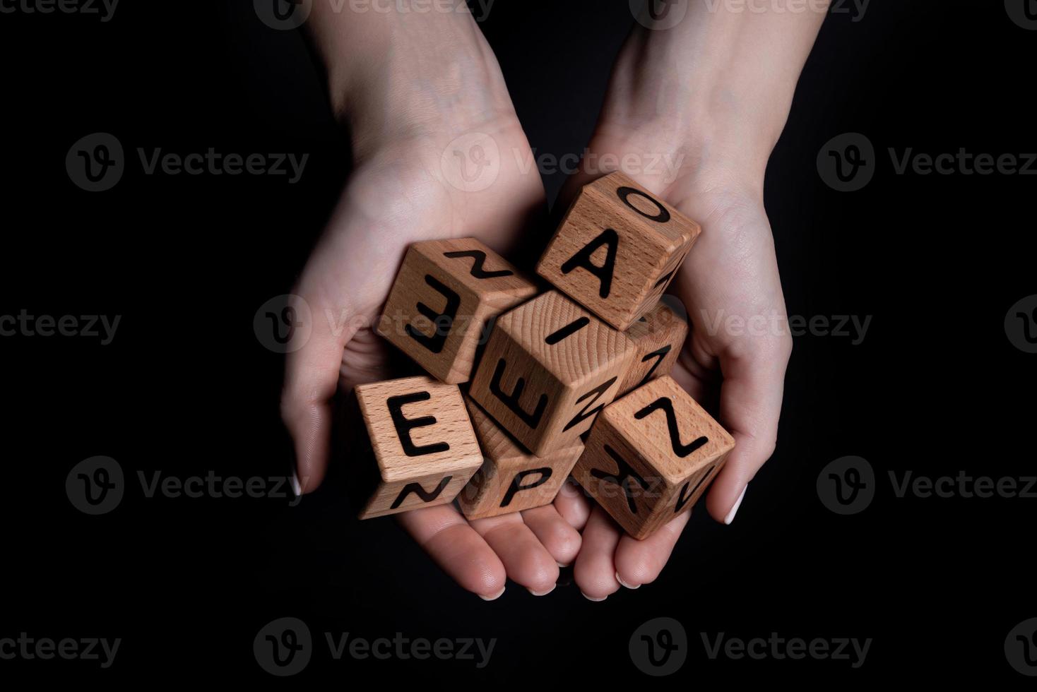 las manos femeninas sostienen un cubo con letras aisladas en negro foto