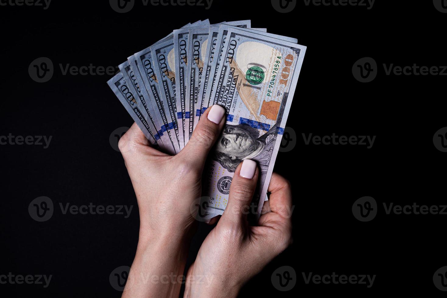 two hands with dollars. Closeup female hand giving money for something with isolated on black background,count, paying, shopping with dollar, corruption, counting dollar banknotes on black photo