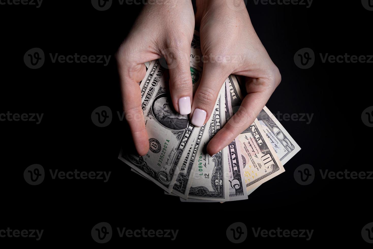 two hands with dollars. Closeup female hand giving money for something with isolated on black background,count, paying, shopping with dollar, corruption, counting dollar banknotes on black photo