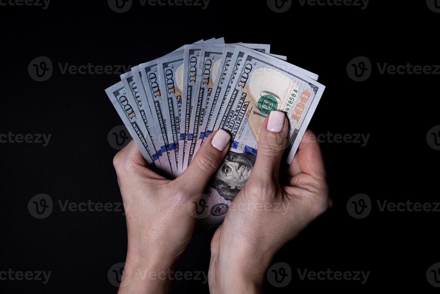 two hands with dollars. Closeup female hand giving money for something with isolated on black background,count, paying, shopping with dollar, corruption, counting dollar banknotes on black photo