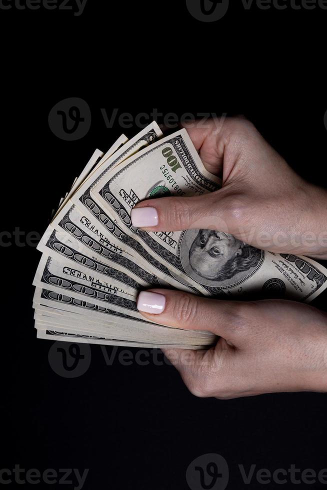 two hands with dollars. Closeup female hand giving money for something with isolated on black background,count, paying, shopping with dollar, corruption, counting dollar banknotes on black photo