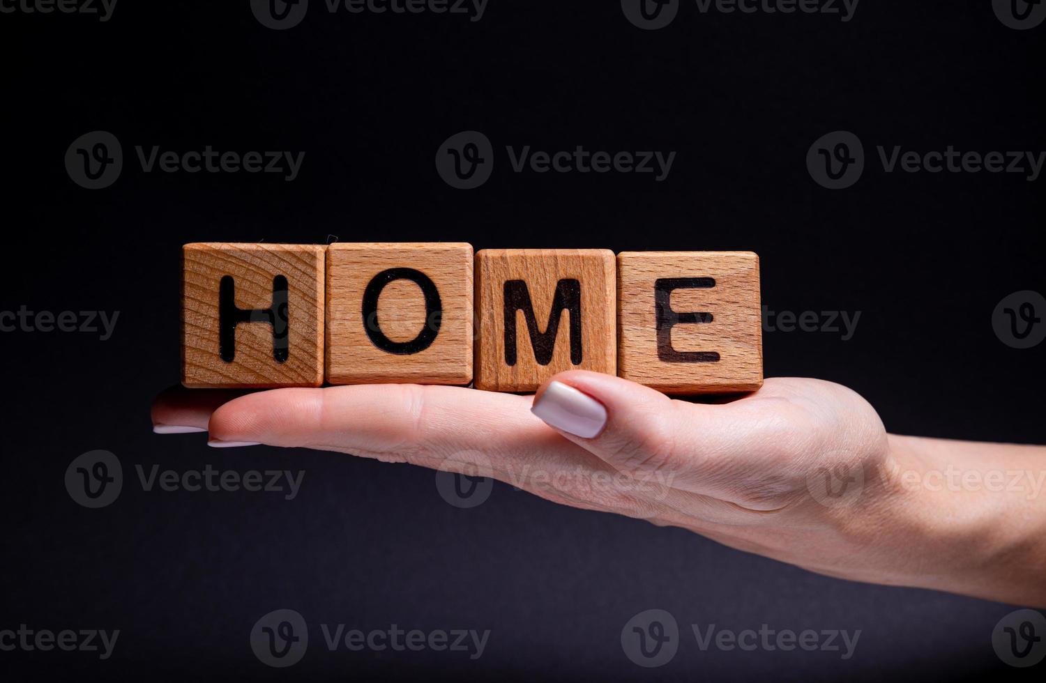 Female hands holds a cube with letters, wooden cubes with words rent sale , buy and loan. Project for designer on black . Words home learn , health photo