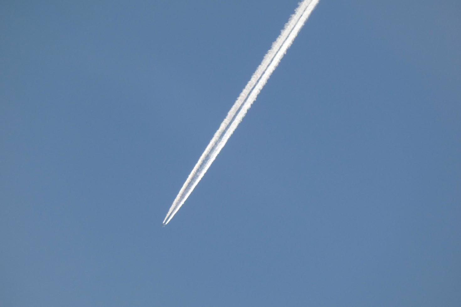 white wake of an airplane under the blue sky photo