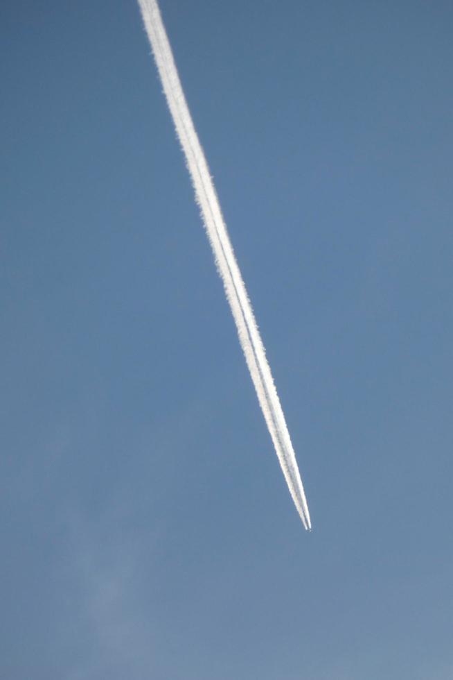 white wake of an airplane under the blue sky photo