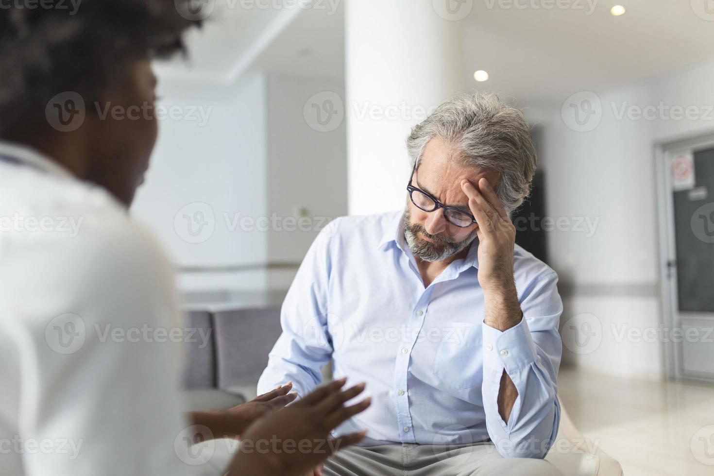 Kind female doctor embracing encouraging happy senior male patient in hospital. Happy healthy older man and his physician enjoying talking. Elderly medical health care concept. photo