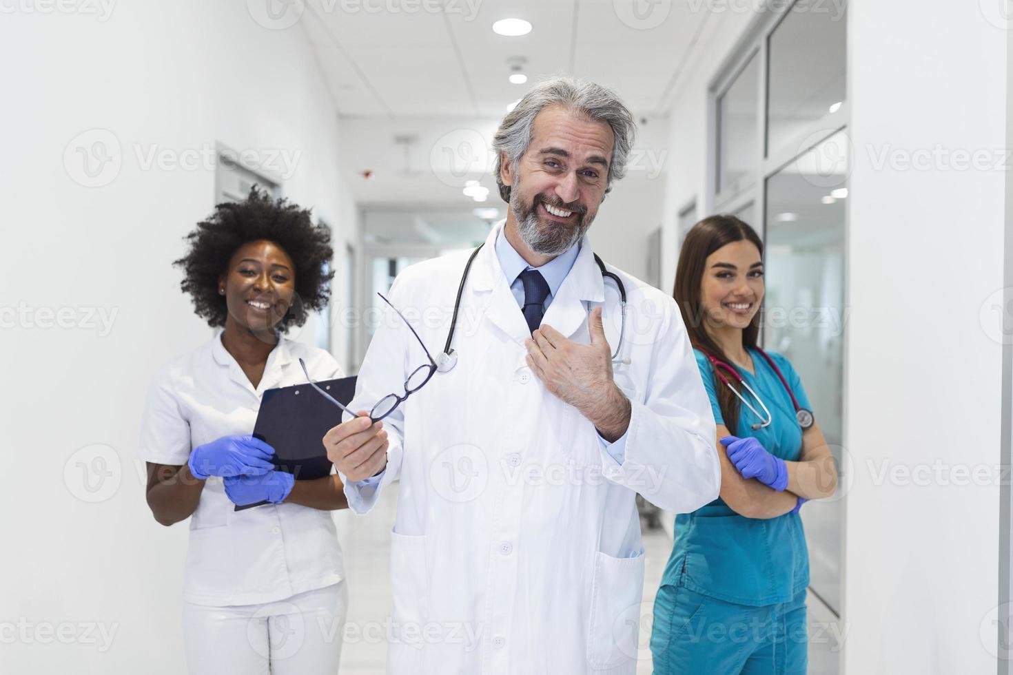 clinic, profession, people, health care and medicine concept - happy group of medics or doctors at hospital corridor. Group of doctors at the hospital hall - healthcare and medicine concept photo