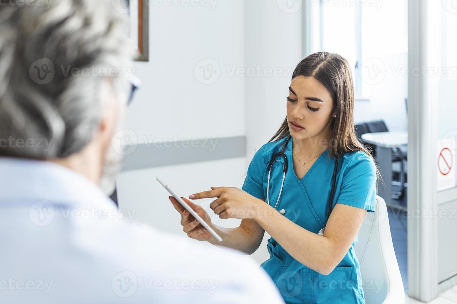 médico consultando al paciente en la sala de espera del hospital. paciente sentado. diagnóstico, prevención de enfermedades, atención médica, servicio médico, consulta o educación, concepto de estilo de vida saludable foto