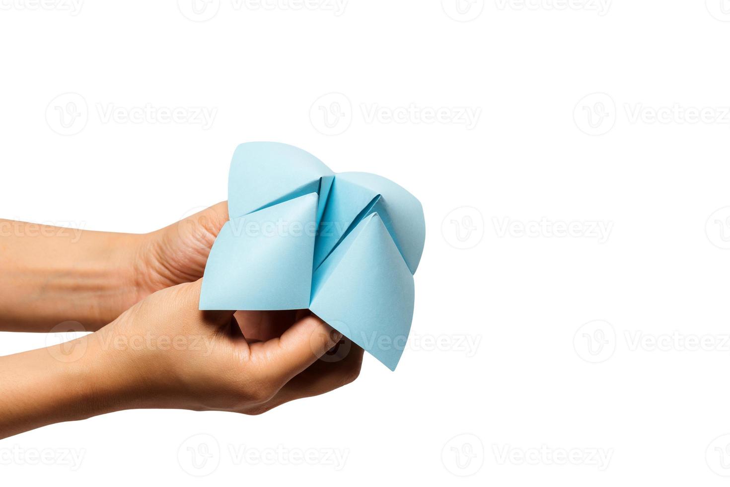 Hand in a paper fortune teller isolated on white background. photo