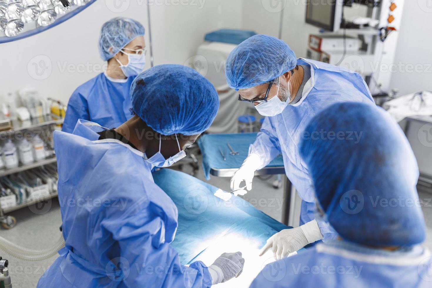 Medical team of surgeons in hospital doing minimal invasive surgical interventions. Surgery operating room with electrocautery equipment for cardiovascular emergency surgery center. photo