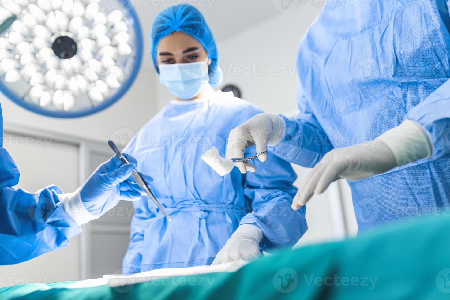 Group of surgeons doing surgery in hospital operating theater. Medical team  doing critical operation. Group of surgeons in operating room with surgery  equipment. Modern medical background 15127739 Stock Photo at Vecteezy