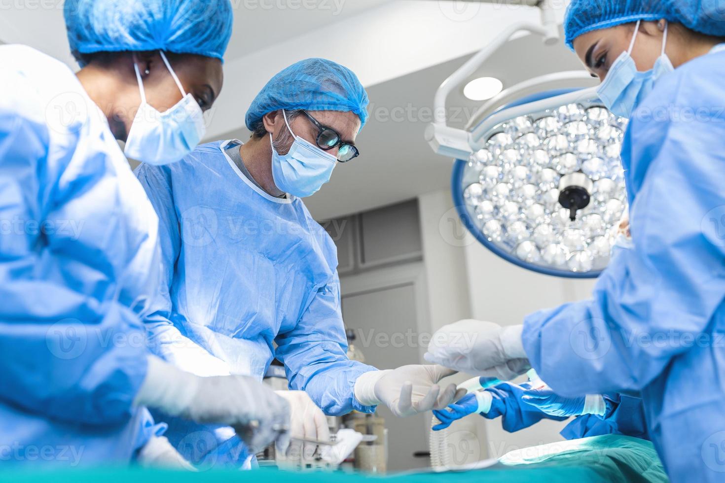 Surgeons performing operation in operation theater. breast augmentation surgery in the operating room surgeon tools implant. Medical care concept. photo