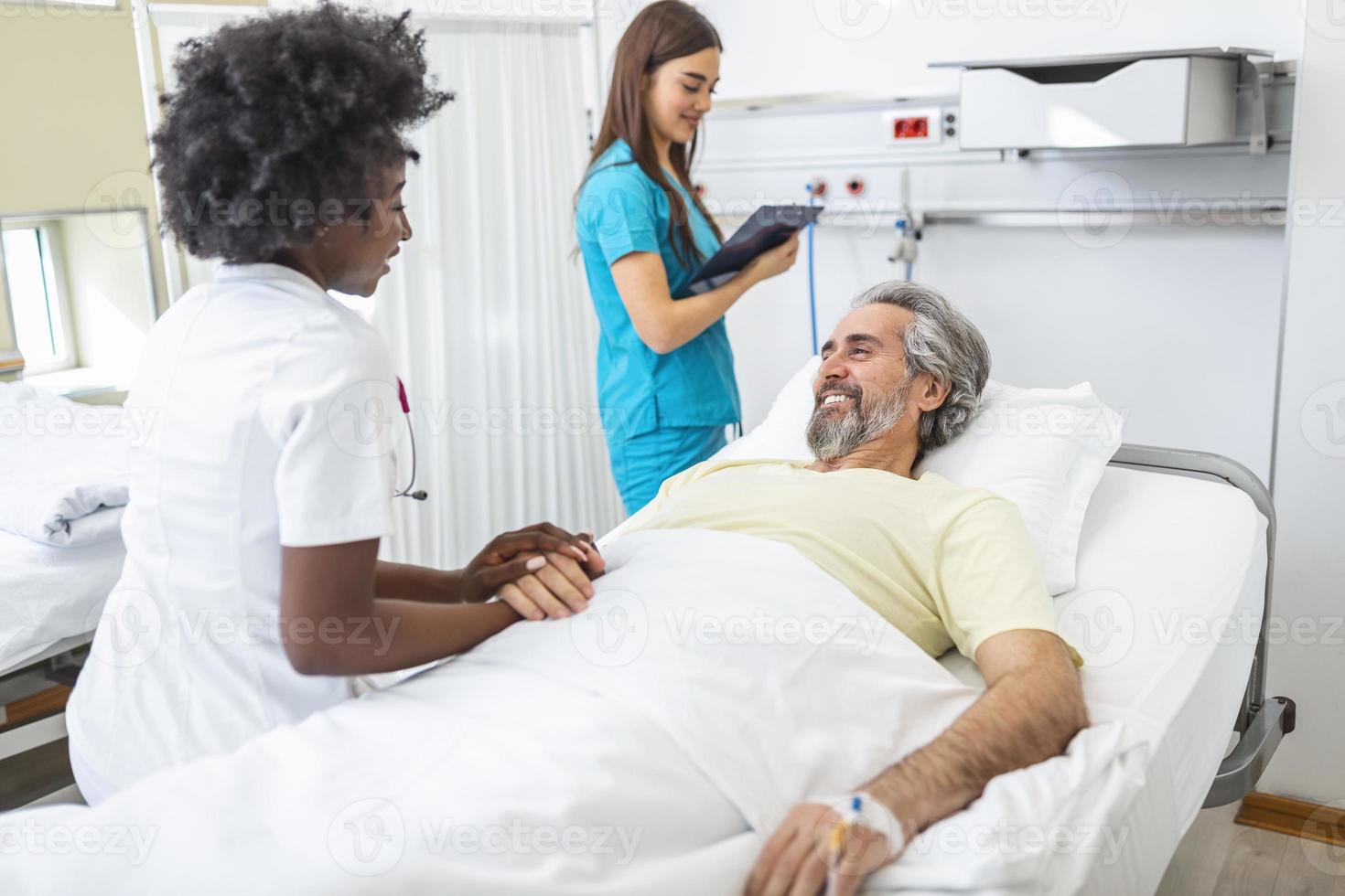 médico profesional que consulta y reconforta a un paciente anciano en la cama de un hospital o asesora en el diagnóstico de salud. médico o enfermera sosteniendo las manos del paciente mayor y consolándolo foto