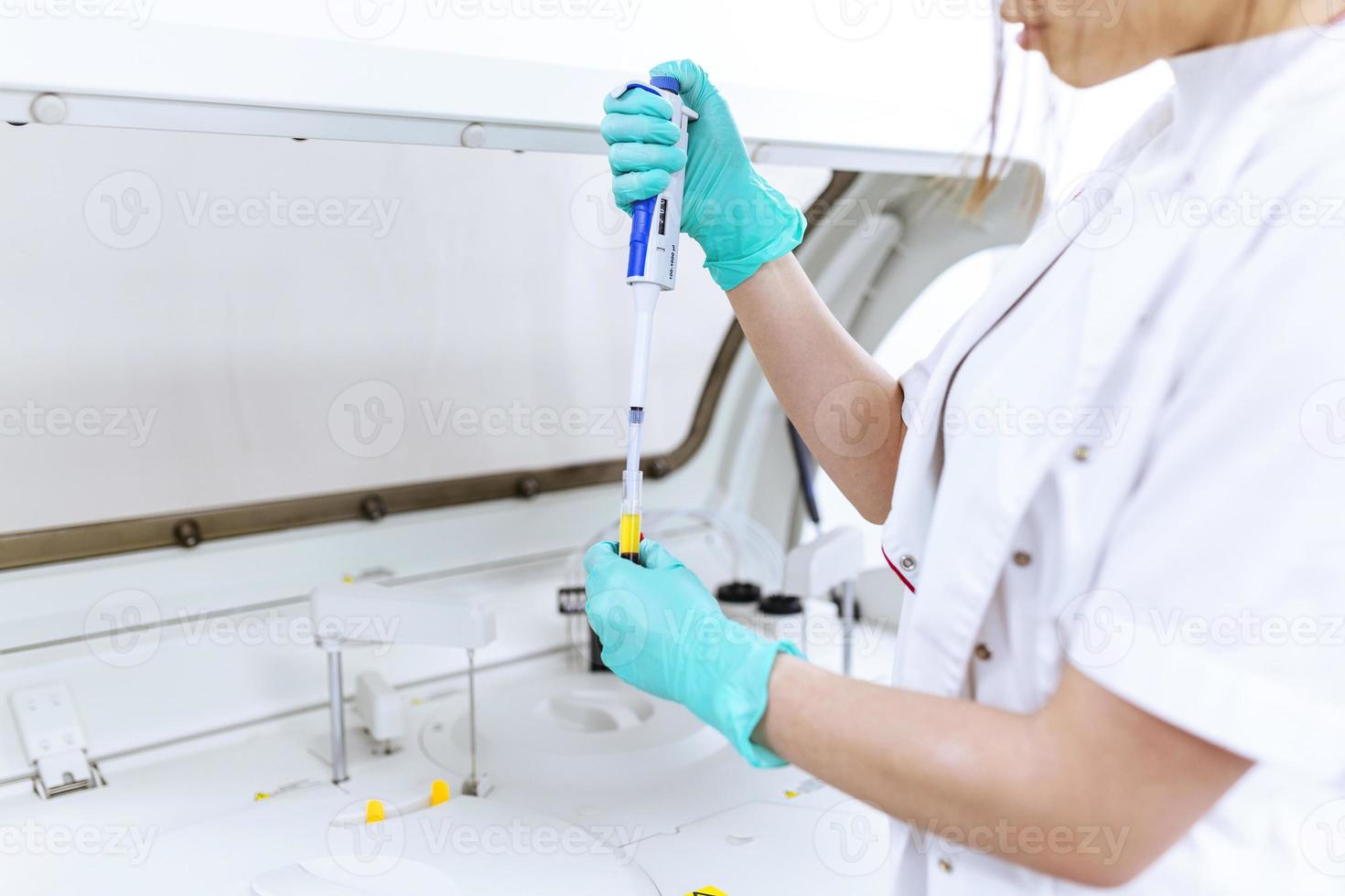 Interior of clean modern white medical or chemistry laboratory background. Laboratory scientist working at a lab with micro pipette and test tubes. Laboratory concept with woman chemist. photo