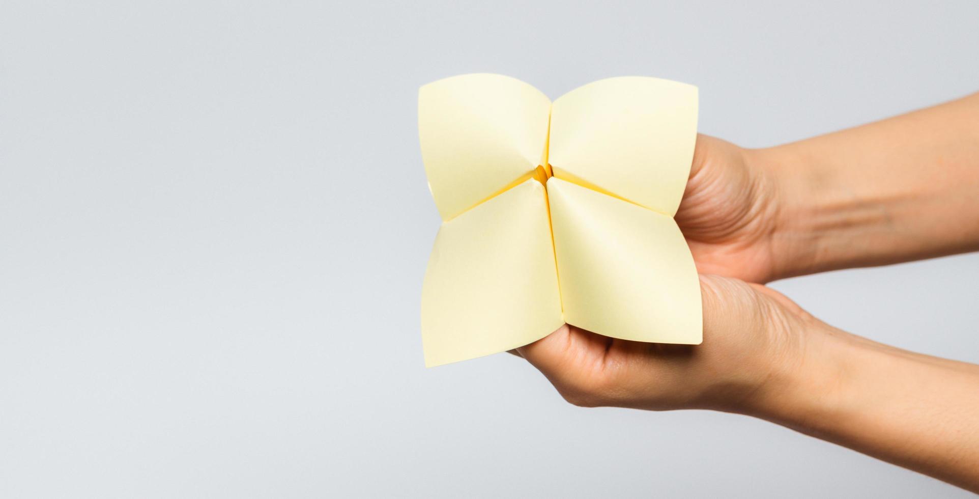 Hand in a paper fortune teller isolated on white background. photo