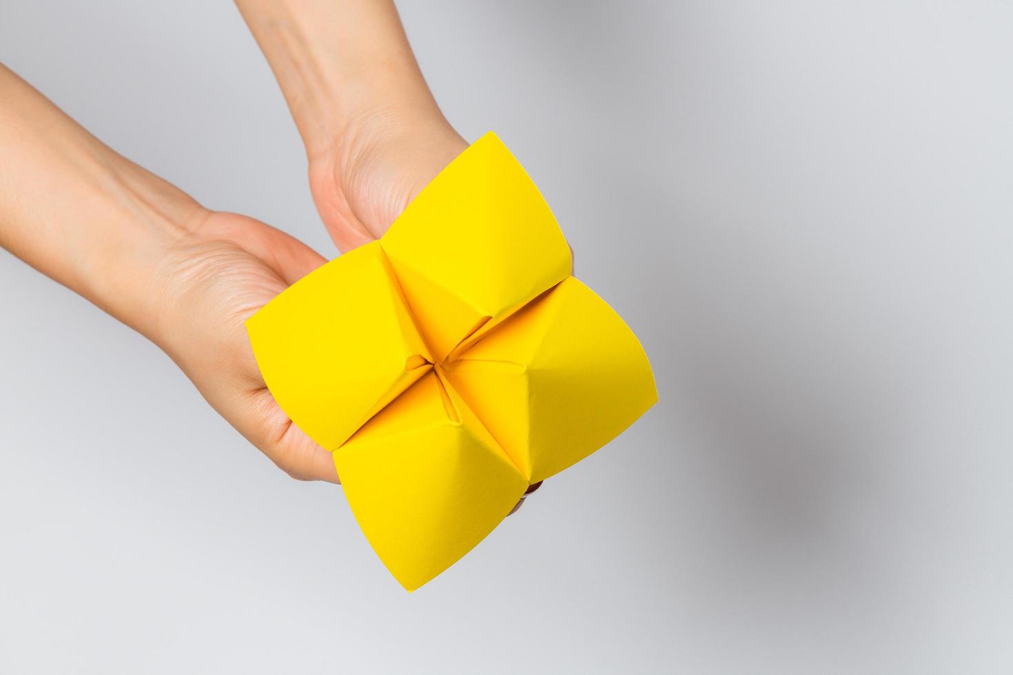 Hand in a paper fortune teller isolated on white background. photo