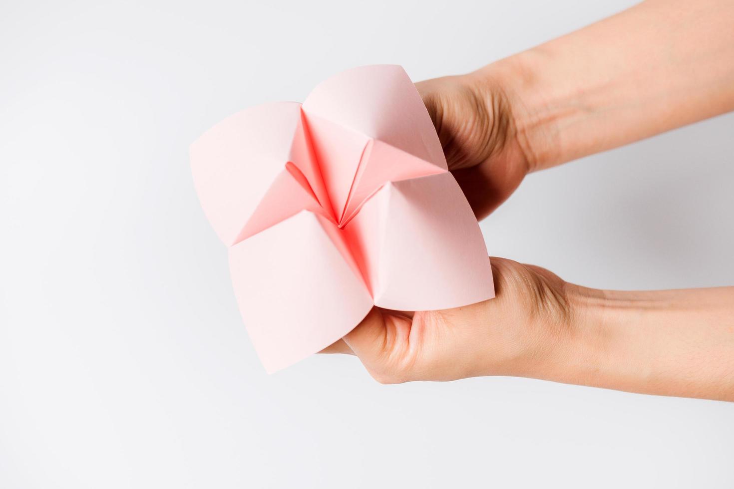 Hand in a paper fortune teller isolated on white background. photo