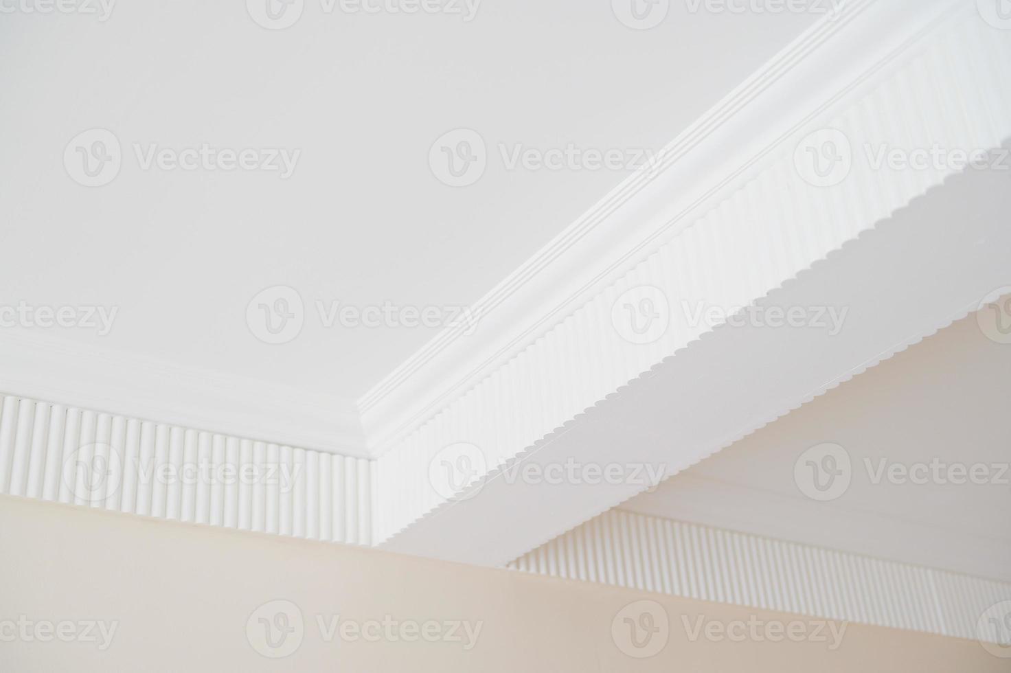 Detail of corner ceiling with intricate crown molding in the white room photo