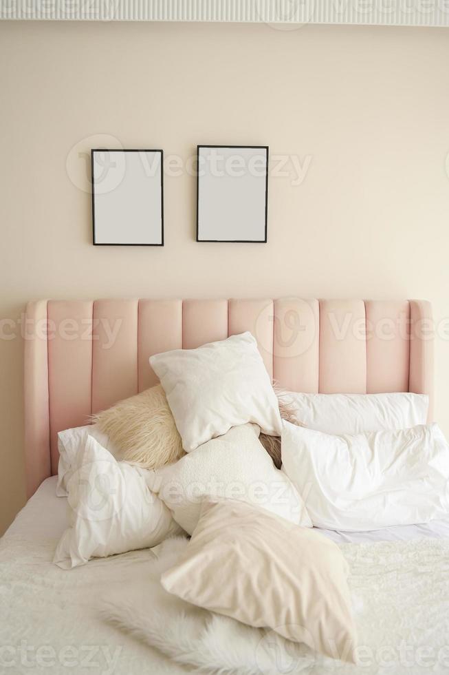 Warm and cozy interior of bedding room space with pink bed, mock up poster frame. Cozy home decor. photo