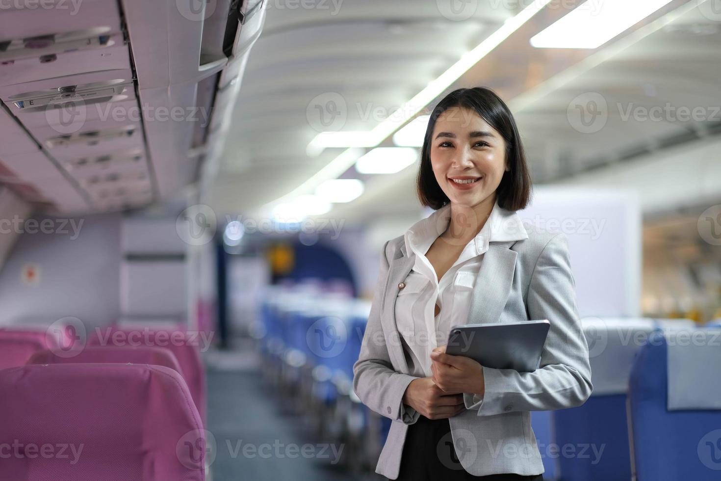 Attractive caucasian female passenger of airplane sitting in comfortable seat while working at modern laptop computer with mock up area using wireless connection on board photo