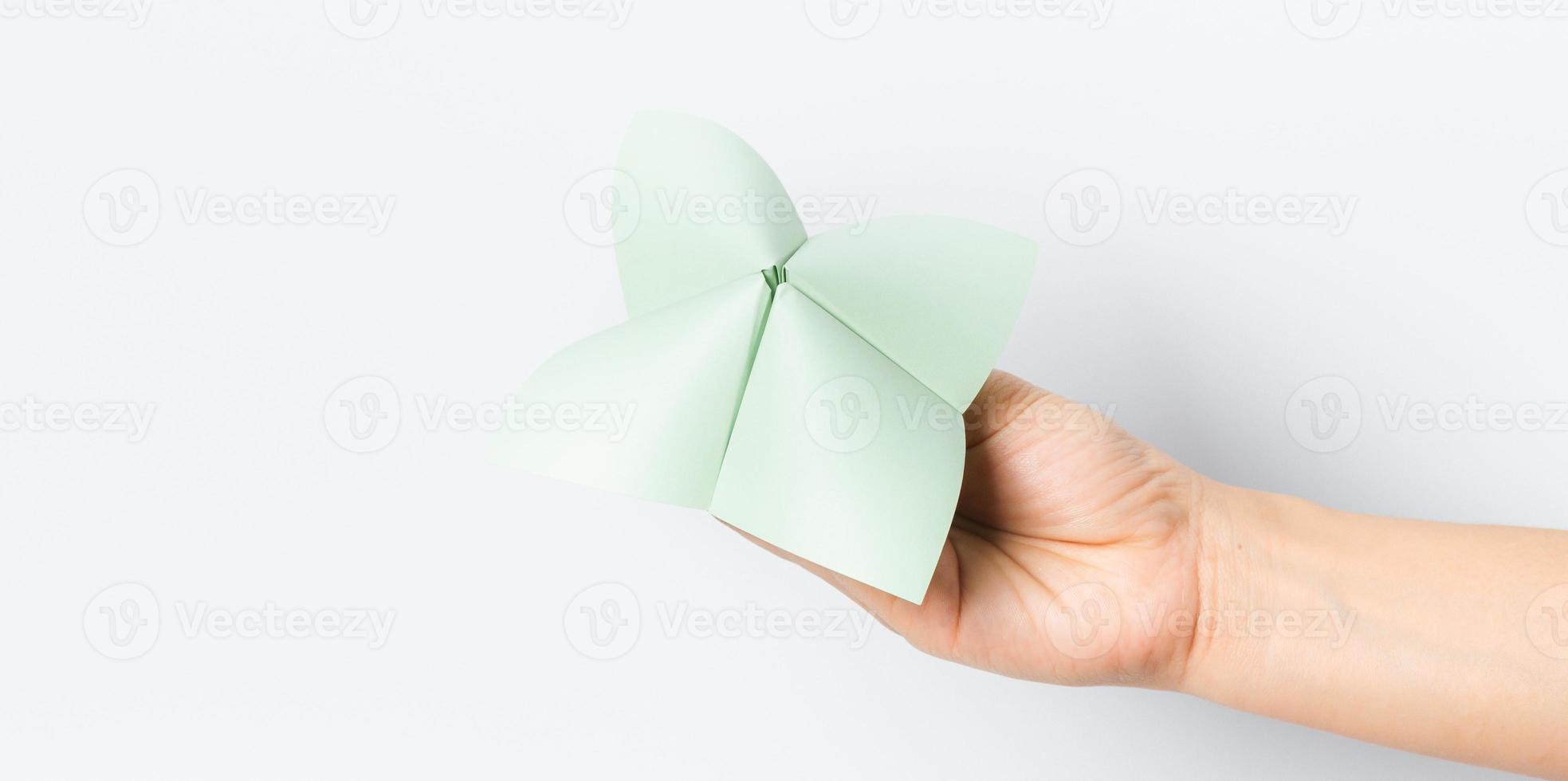 Hand in a paper fortune teller isolated on white background. photo