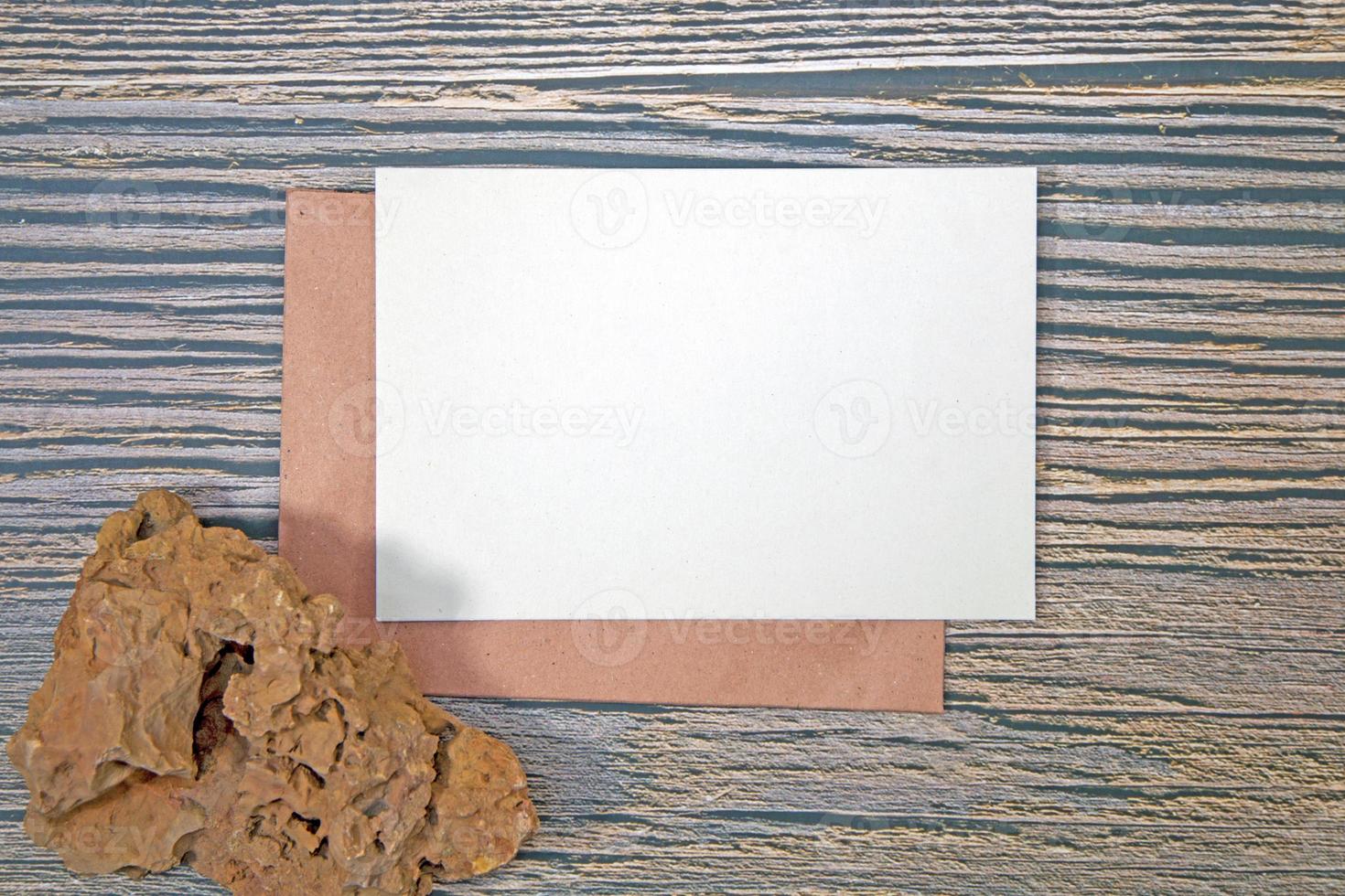 A5 paper greeting card mockup with grunge Stone on wooden background photo