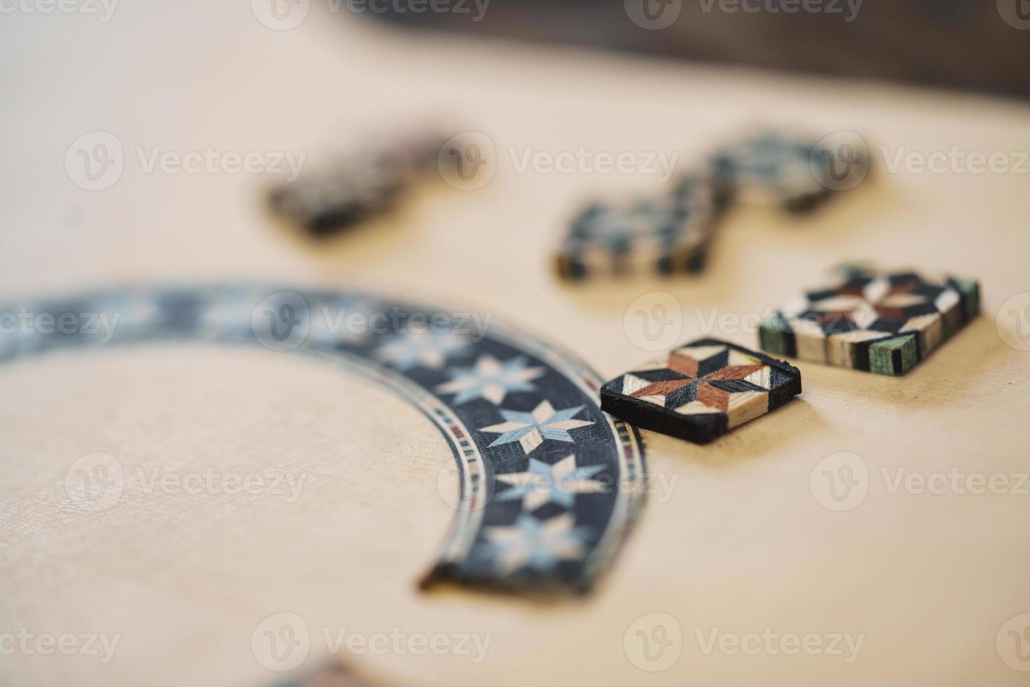 Wooden blocks with ornaments of taracea, placed on Spanish flamenco guitar in luthier workshop. photo