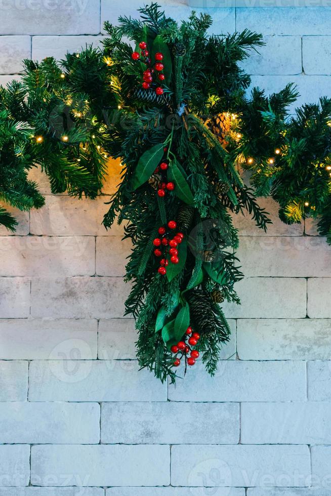 Christmas fir tree with lights on white brick background with copy space photo