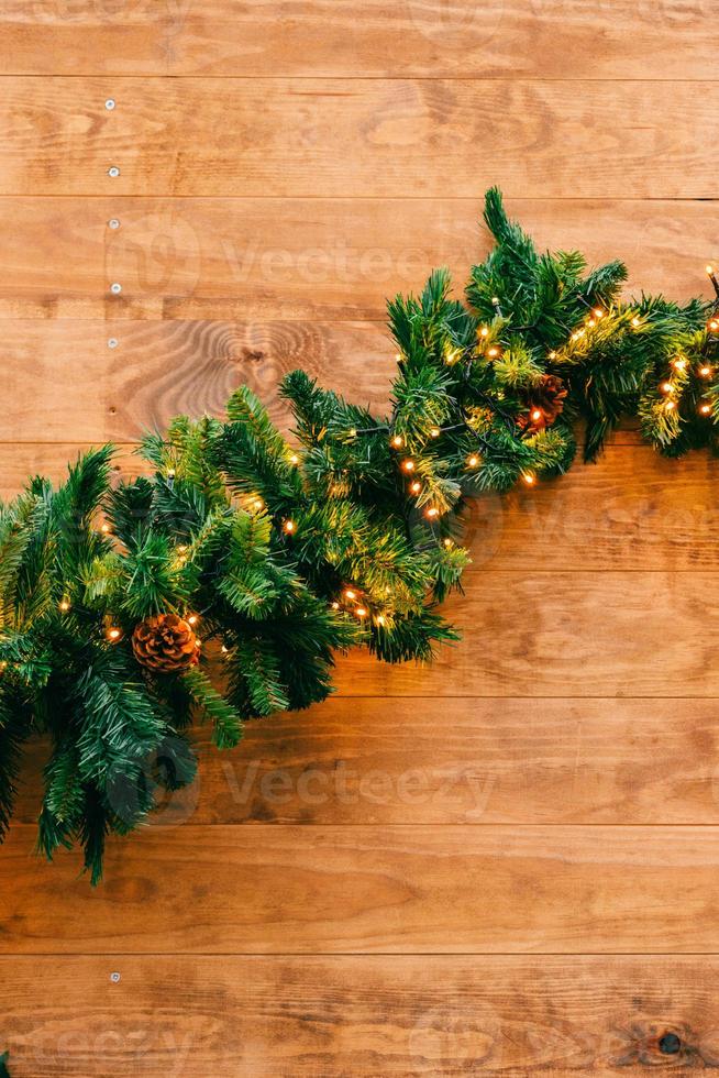 Christmas fir tree with lights on wooden background with copy space photo