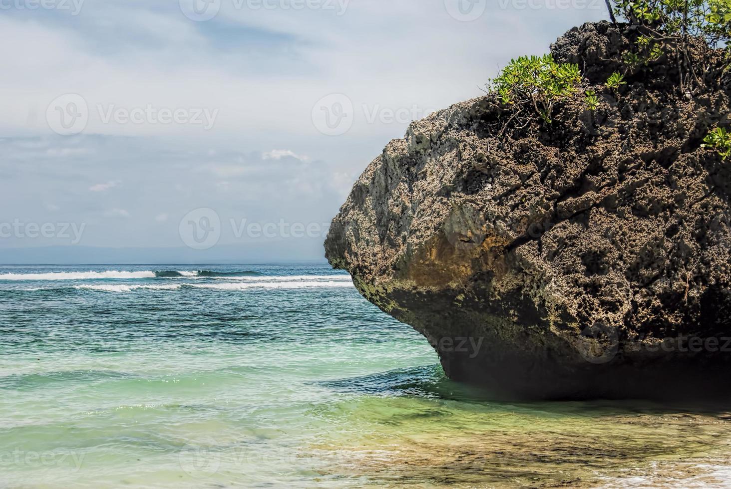 Tropical beach with panoramic views and waves, rocks and sand background photo