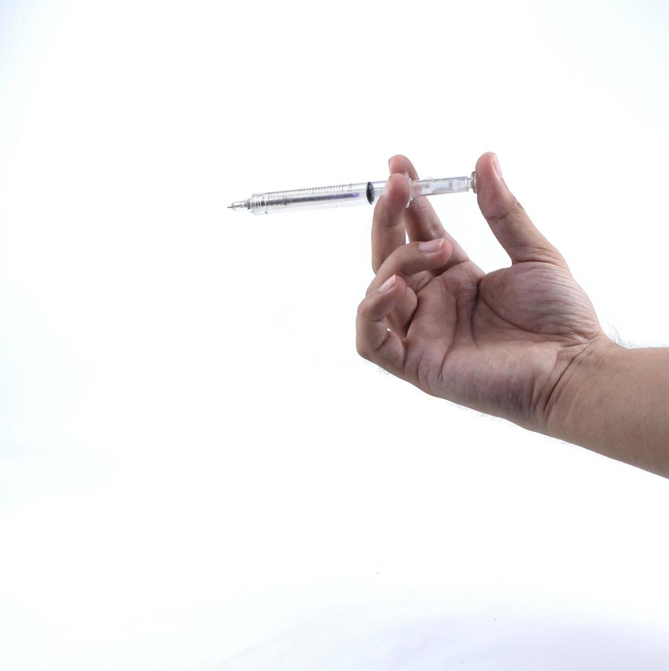 hand holding a small syringe isolated on a white background photo