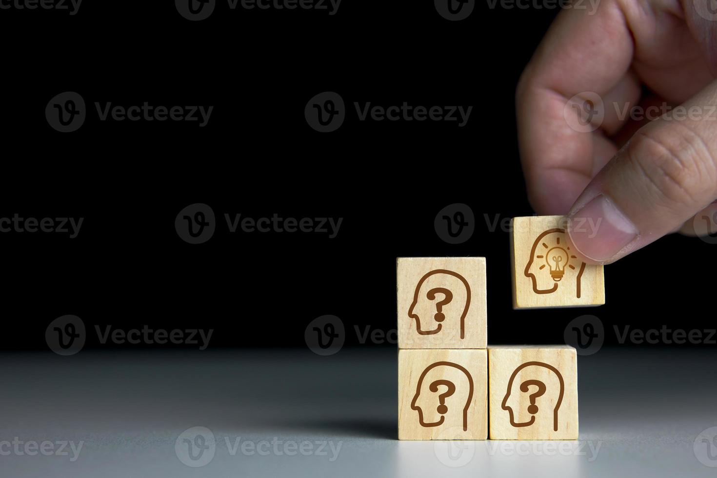 concept of Business innovation ideas and creativity. Hand picked wooden cube block with human head symbol and light bulb icon. photo