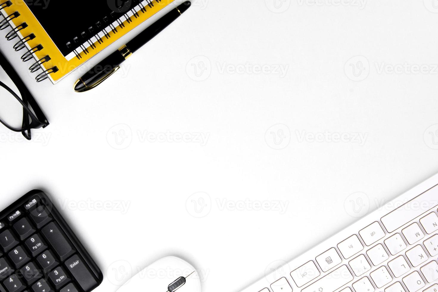 top view of modern white office desk with computer keyboard, blank notebook page and other equipment on white background. Workspace concept, workspace management style, business design space with copy photo