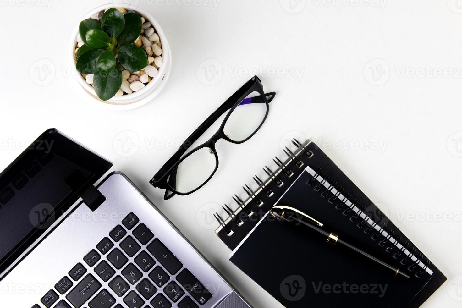 top view of modern white office desk with computer keyboard, blank notebook page and other equipment on white background. Workspace concept, workspace management style, business design space with copy photo