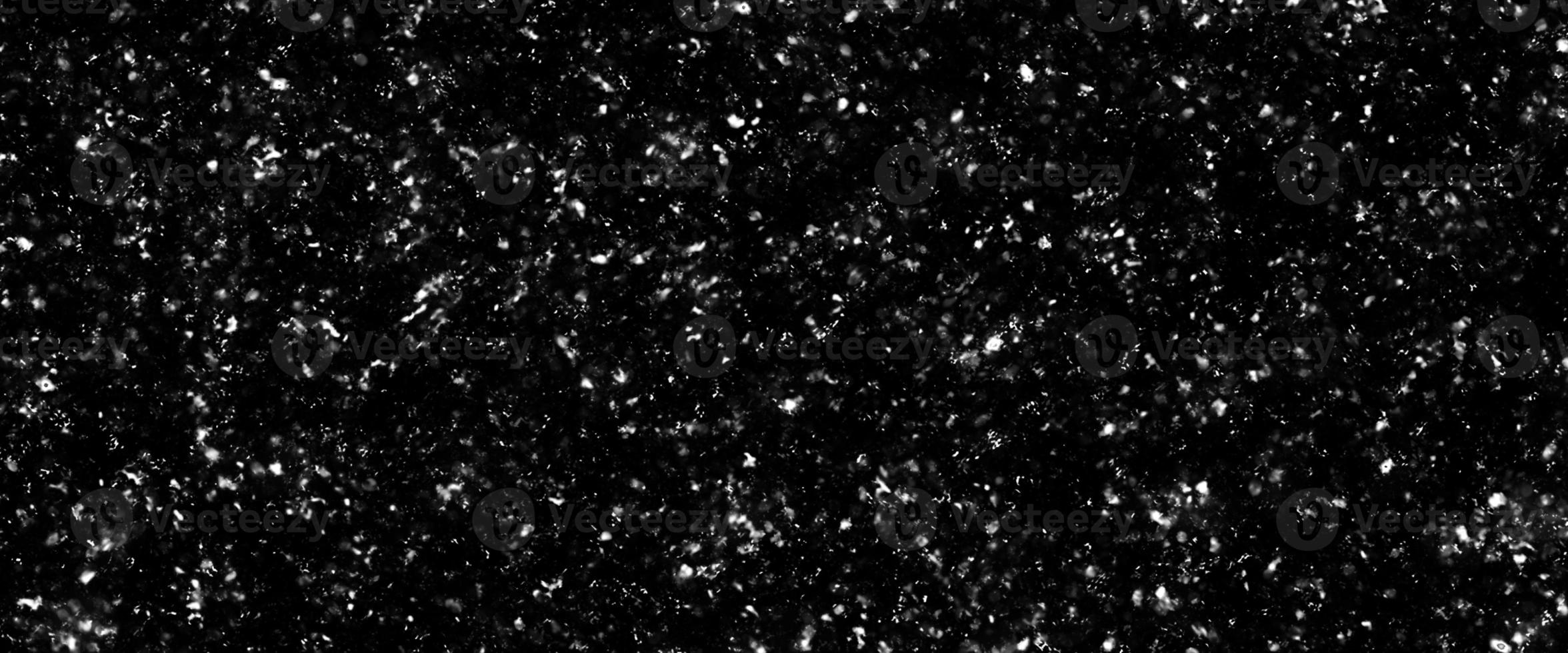 Snowfall bokeh on black background. Many snowflakes in flying in the air. Winte night snowfall and blizzard of snow at. Blur bokeh light effect creative background photo